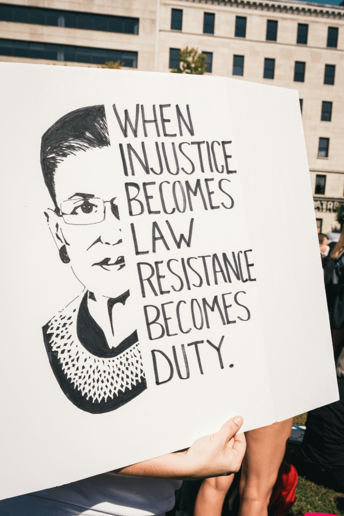 Bilde av kvinne med plakat " When injustice becomes law resistance becomes duty.